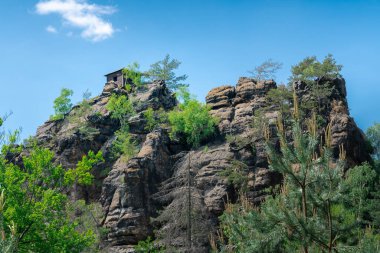 Rudolf 'un kumtaşı kayasının tepesindeki küçük kır evi Bohemian İsviçre' nin pitoresk manzarasında güneşli bir günde aşağıdaki patikadan izlendi.