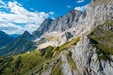 Güneşli bir yaz gününde, Sudwand Hutte ve Hoher Dachstein 'ın kablodan görüntüsü. Dik kayalıklar ve Avusturya Alpleri 'nin aşağısında geniş bir dağlık vadi..