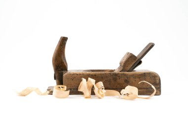 Yatay düşük açılı, beyaz arka planda izole edilmiş küçük, kaliteli ahşap bir stüdyo fotoğrafı. Üzerinde tahta solucan delikleri olan eski bir marangoz aleti. İnce ahşap talaşı. Marangozluk kavramı.