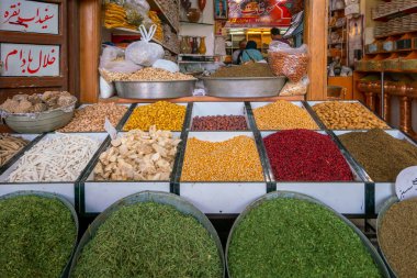 Kerman, İran - 04.19.2019: İran pazarındaki bir baharat dükkanının önündeki renkli tahıl ve baharatlar.