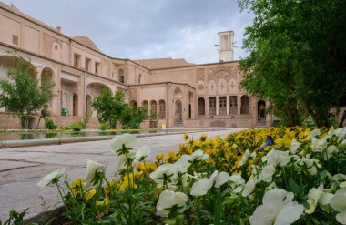 Kashan, İran - 04.19.2019: Zengin dekore edilmiş Borujerdi Evi 'nin avlusu, Qajar döneminden ünlü tarihi ev. Havuz, rüzgar kuleleri, küçük Pers bahçesi..