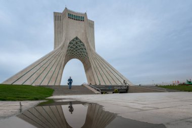 Tahran, İran - 04.10.2019: İran 'daki Azadi Kulesi Sanatsal ve Kültür Kompleksi. Özgürlük kulesi su yüzeyine yansıyor. Merdivenlerden inen adam..