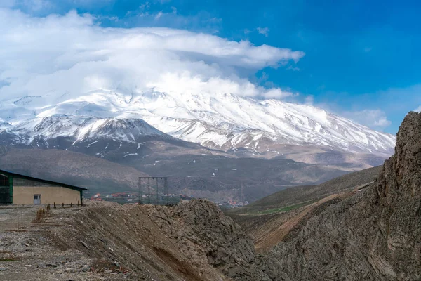 Nuvens se reúnem perto do cume do Monte. Damavand, o mais alto estratovulcão da Ásia. Tarde parcialmente nublada nas montanhas do Irão. — Fotografia de Stock