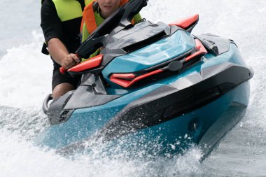 Hel, Polonya - 08.01.2021: Bir sürü damlacığın havada uçtuğu bir su motoruyla can yeleği giyen erkek ve çocuğun yakın plan çekimi. Baltık Denizi 'nde su sporları.