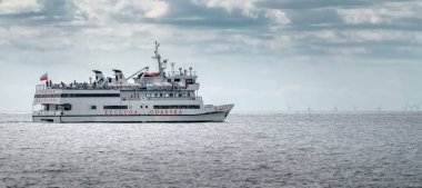 Hel, Polonya - 08.01.2021: Sisli bir yaz gününde Baltık Denizi 'nden Gdansk' a giden insanlarla dolu bir yolcu gemisi. Baltık sahilinde yaz tatili. Gezinen feribot.