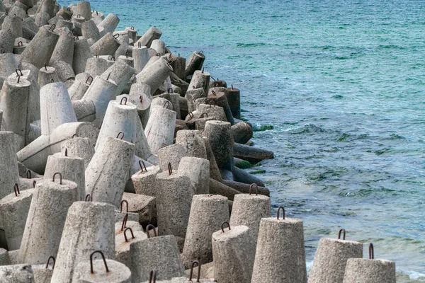 Detalle plano de hormigón tetrápodo dolosa rompeolas con ojos de acero que protege el puerto de Hel, Polonia de las mareas oceánicas. Mar Báltico azul en el fondo. — Foto de Stock