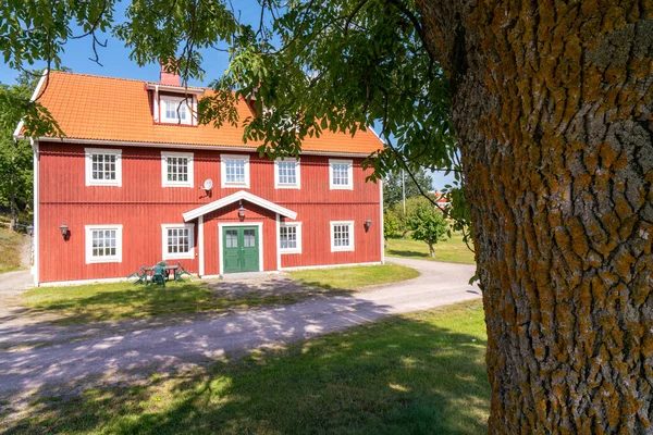 Vastervik, Sweden - 08.23.2021: Typical red wooden countryside house in nature of southern Sweden on a beautiful sunny summer day. Relaxing rural landscape. — Stock Photo, Image