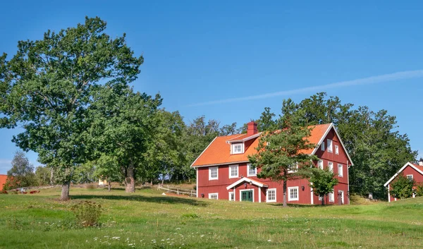 Vastervik, Sweden - 08.23.2021: Typical red wooden countryside house in nature of southern Sweden on a beautiful sunny summer day. Relaxing rural landscape. — Stock Photo, Image