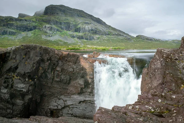 Nahaufnahme, Weitwinkelaufnahme des mächtigen Stuor Muorkkegarttje Wasserfalls am Fluss Lulealven an einem leicht bewölkten Tag des arktischen Sommers. Stora Sjofallet Nationalpark, Schweden. — Stockfoto