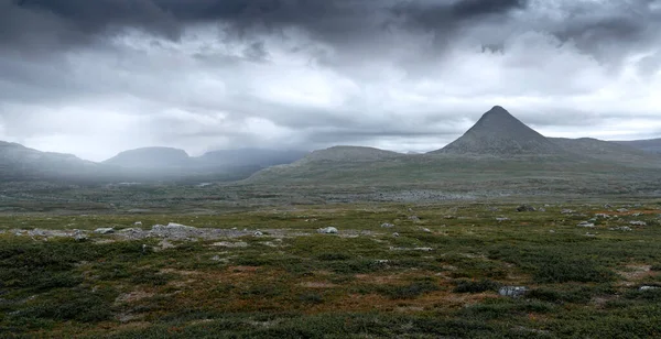 Epic panorama view of Mt Slugga in Swedish Lapland on a very cloudy day of arctic summer. Dramatic weather and landscape of arctic wilderness. Backpacking in Stora Sjofallet National Park. — Stock Photo, Image