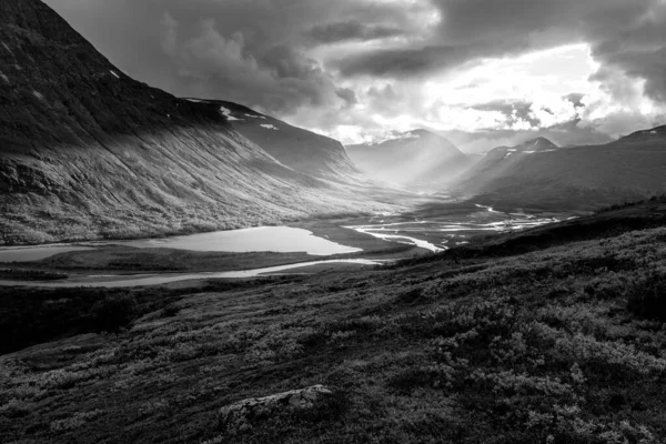 Remote harsh arctic landscape in rough weather in Sarek national park, Swedish Lapland. Heavy clouds with rays of light coming through. — Stock Photo, Image