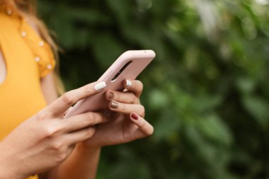 Genç bir kadın tarlada fotoğraf çekiyor.