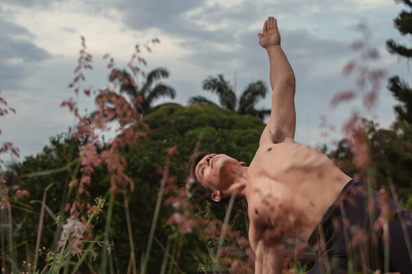 Молодой латиноамериканец практикующий йогу