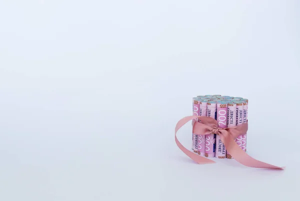 Billetes ucranianos en un rollo con cinta de regalo. — Foto de Stock