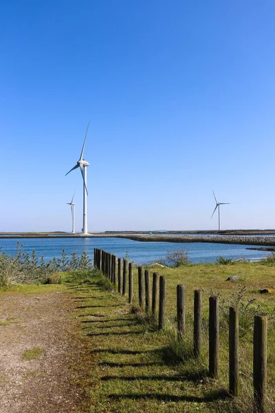 Windmills for electric power production with wooden fence. — Stock Photo, Image