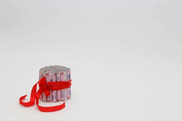 200 gryvnias en un rollo con una cinta de regalo roja. En un blanco con espacio para el texto — Foto de Stock