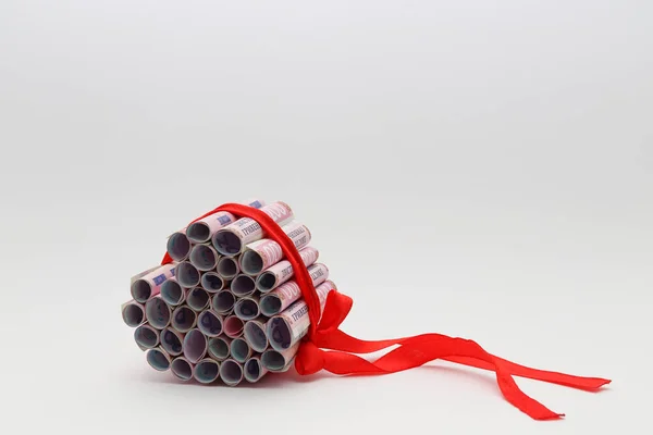 Ukrayna hrivnalarından yapılmış bir kalp. 200 Hryvna banknotları. Kırmızı kurdeleli para 