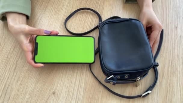 4K Femme prend téléphone portable avec écran vert de son sac. — Video