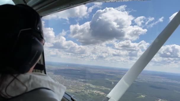 4k Flicka med hörlurar njuter av flygning i ett litet flygplan. — Stockvideo