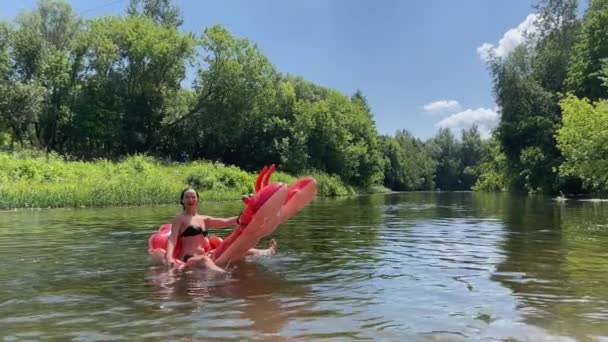 4k Kız şişme kırmızı bir ıstakozun üzerinde yüzüyor.. — Stok video