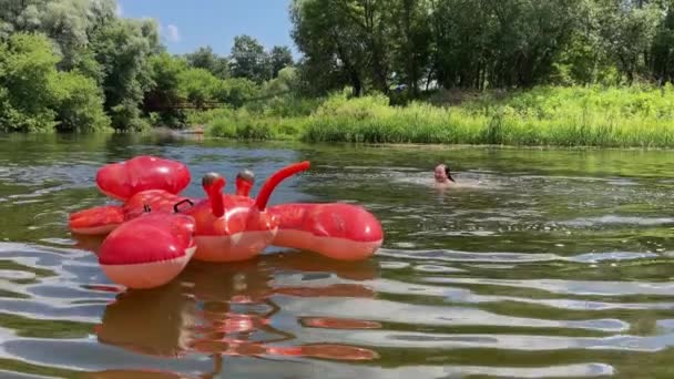 4k Mädchen schwimmen im Fluss mit einem aufblasbaren großen Hummer. — Stockvideo