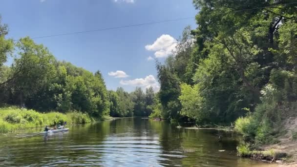 4k Familie im Kajak schwimmen auf dem Fluss. Abstieg entlang des schmalen Flusses. — Stockvideo