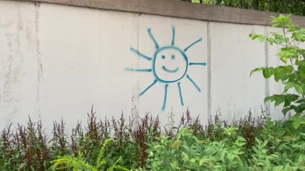 4k Pared de hormigón con sol sonriente pintado en ella. — Vídeos de Stock