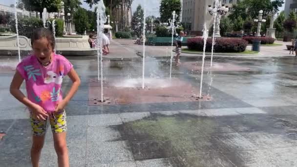 4k Pequeña chica sonriente mojada después de caminar cerca de la fuente. — Vídeos de Stock