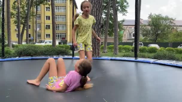 4k Sisters Zwillinge springen im Sommer auf einem Trampolin. — Stockvideo