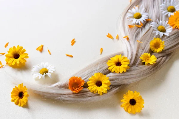 Cabelo loiro com flores de camomila e calêndula. — Fotografia de Stock
