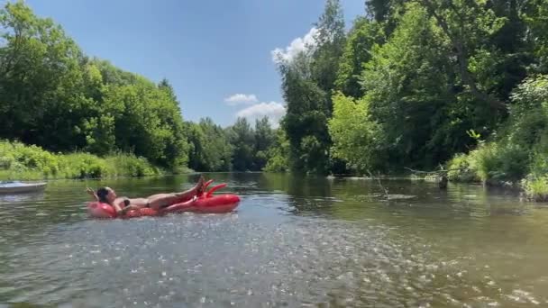 4К Девушка на надувном лобстере в реке. Активный отдых на воде, — стоковое видео