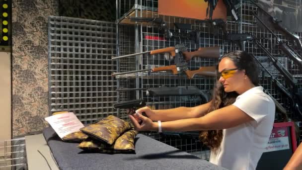 4k Una mujer aprende a disparar y cargar el arma en el campo de tiro — Vídeo de stock