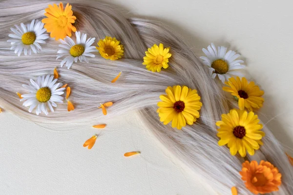 Flores medicinais com cabelo loiro brilhante liso. Flores de verão no cabelo. — Fotografia de Stock