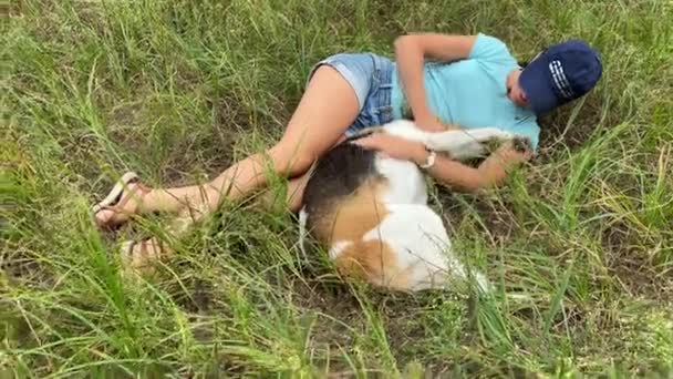 4k Meisje met de hond liggend op het grasveld in het park. — Stockvideo