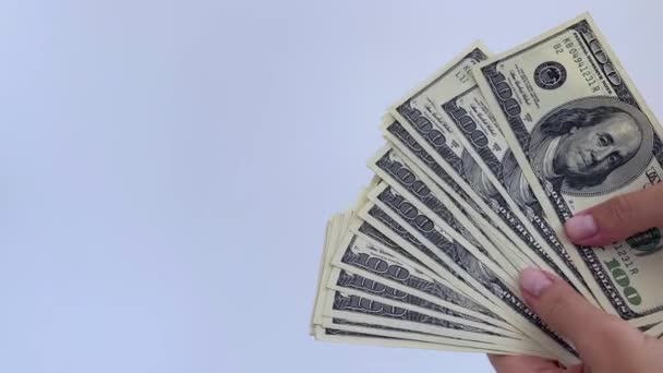 4k mains féminines tenant des dollars américains sur un fond blanc. — Video