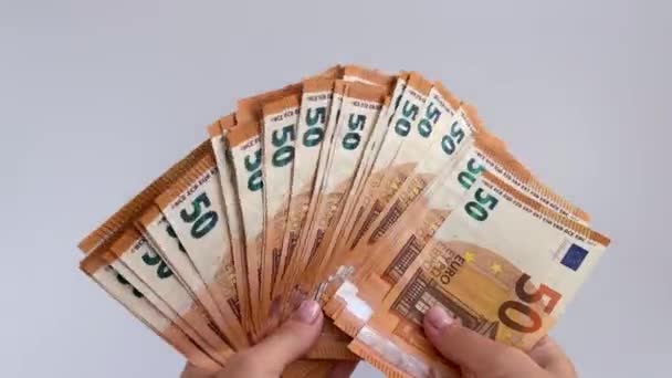 Abanico 4k de billetes de 50 euros ondeando en una mano sobre un fondo blanco. — Vídeos de Stock