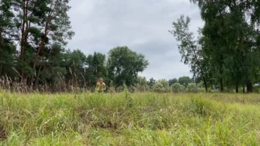 4K Küçük kız ormana doğru koşuyor ve zıplıyor. 