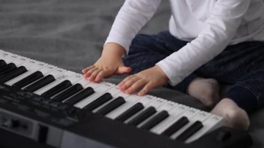 Piyano çalan küçük bir çocuk. Yakın çekim, 4k görüntü
