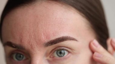 Kalıcı makyajdan sonra iyileşen kaşlarını gösteren bir kadın. - Yakın çekim. 4k görüntü