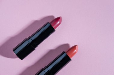 Açık pembe arka planda bir çift ruj. Genel kozmetik ürünleri illüstrasyonu.