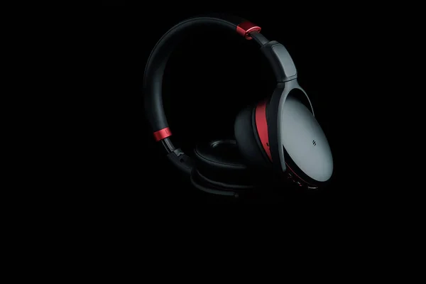 Black and red headphones on black. Music technology.