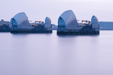 Doğu Londra 'da Thames bariyeri gün doğumu. Uzun pozlama. Dalgalar alçak.