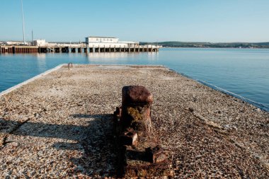 Old donck cleat in Weymouth harbor in the morning. Pier in the horizon. Tourism in England.