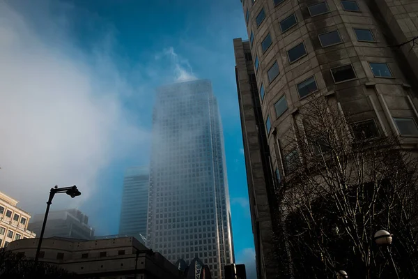 Canary Wharf skyscraper under the fog. Unusual morning in London.