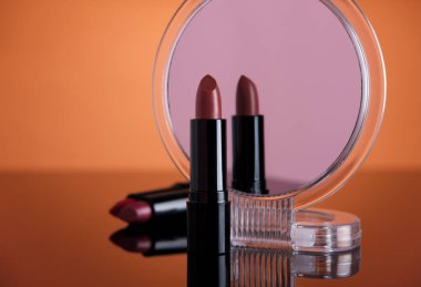 Yansıtıcı yüzeyde ruj ve kozmetik ayna seti.