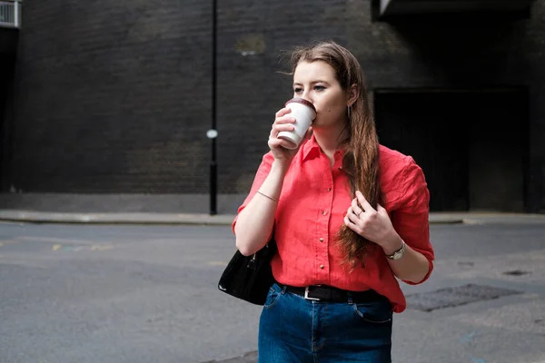 Una Joven Con Una Camisa Roja Tomando Café Calle Calle —  Fotos de Stock