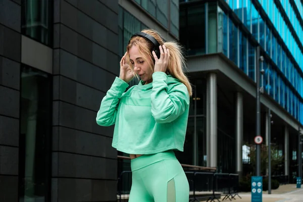 Ελκυστική Ταιριάζει Ώριμη Γυναίκα Πράσινο Ντύσιμο Αθλητισμού Απολαμβάνοντας Μουσική Ακουστικά — Φωτογραφία Αρχείου
