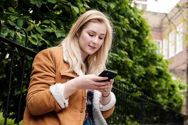 Retrato Una Mujer Joven Usando Smartphone Ella Lleva Abrigo Marrón — Foto de Stock