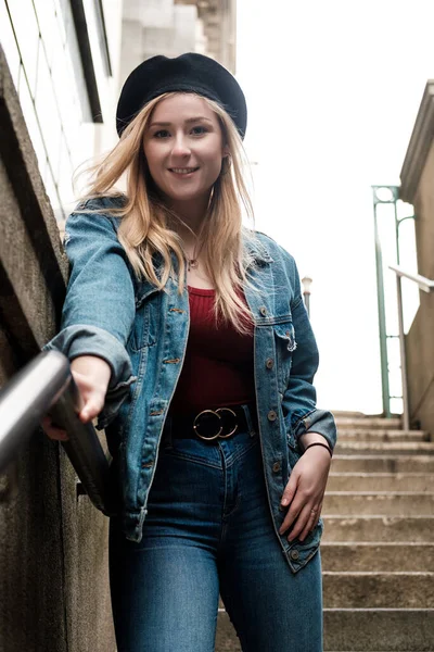 Молодая Блондинка Позирует Лестнице Берете Джинсовой Куртке Брюках Красной Футболке — стоковое фото