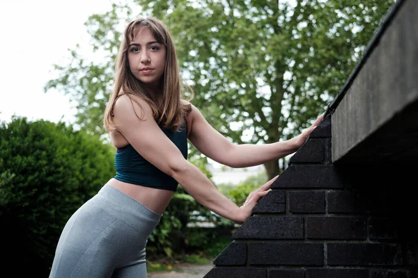 Mulher Fitness Jovem Posando Enquanto Estende Contra Telhado Inclinado Ela — Fotografia de Stock